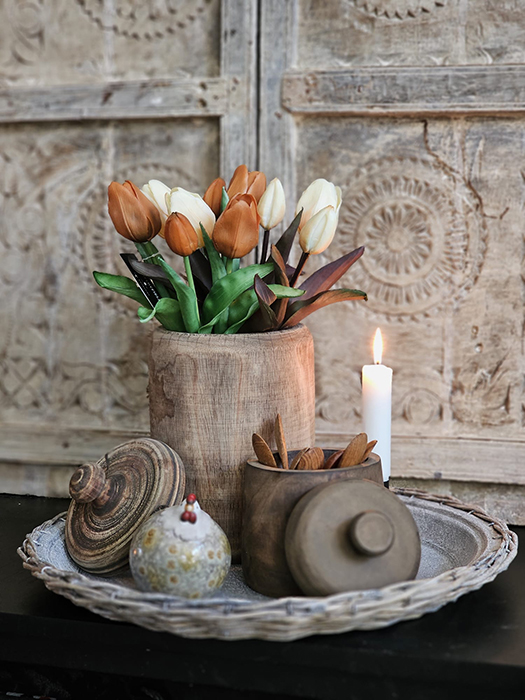 Houten pot gestyleerd met tulpen, kaars en dienblad