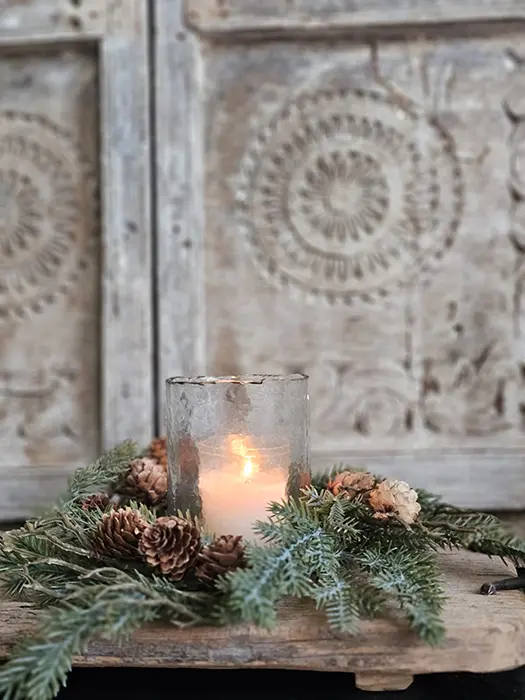 Kerstkrans met dennenappels als kerststuk rond een brandend waxinelicht Kerstkrans met dennenappels als kerststuk rond een brandend waxinelicht